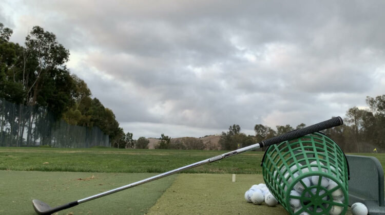 Hitting wedges at the driving range.